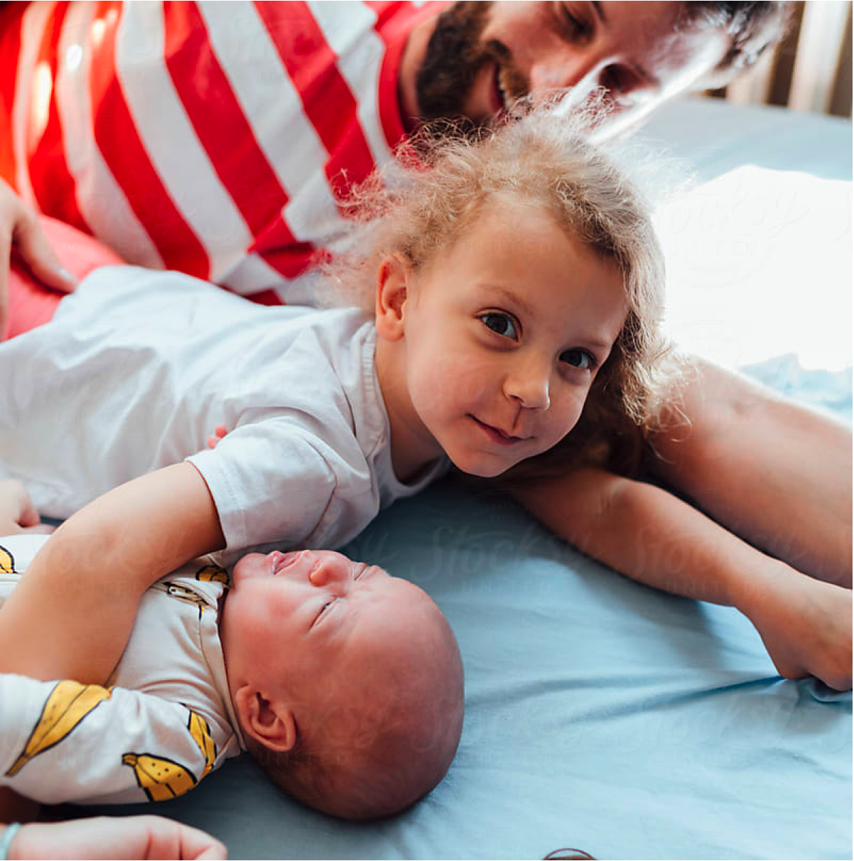 A family of baby, toddler, and dad lounge