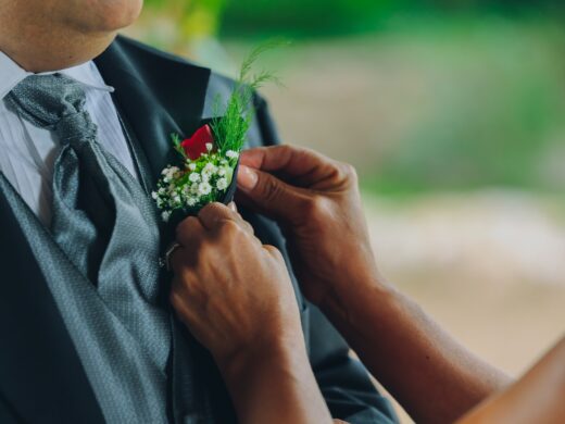 woman pinning boutonniere